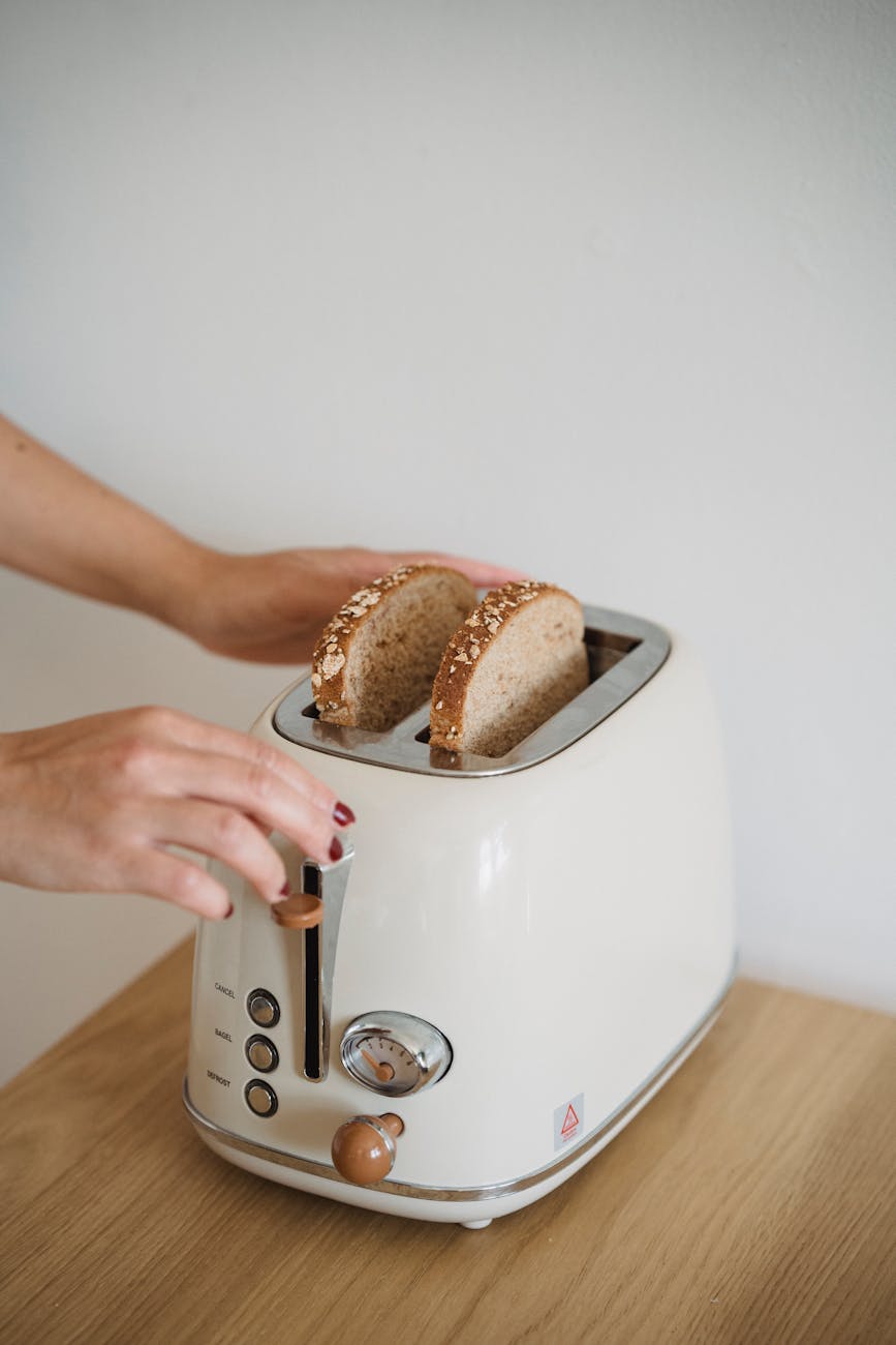 close up of woman putting bread in a toaster
